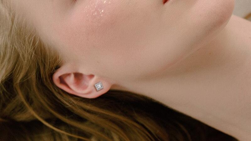 Princess Cut Moissanite Halo Stud Earrings (modelled) Princess Cut Moissanite Halo Stud Earrings